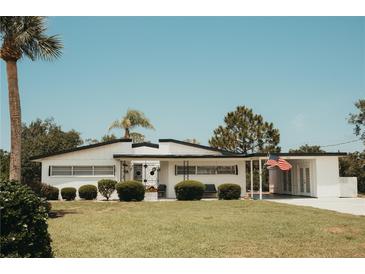 Charming single-story home featuring a well-maintained lawn, trimmed hedges, and a quaint covered porch area at 1980 Forked Creek Dr, Englewood, FL 34223