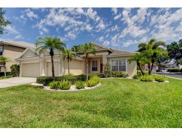 Beautiful single-story home featuring mature landscaping and a three-car garage at 2220 Elizabeth Way, Dunedin, FL 34698