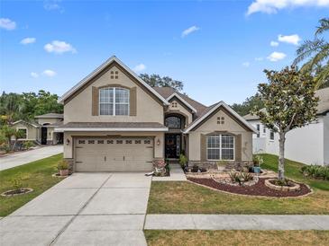 Charming home featuring a manicured lawn, a two-car garage, and lovely stone accents at 35819 Diamond Head Ct, Zephyrhills, FL 33541