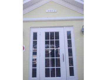 Inviting white-framed front door with glass panels and transom, providing ample natural light into the home at 4872 Beach Se Dr # D, St Petersburg, FL 33705