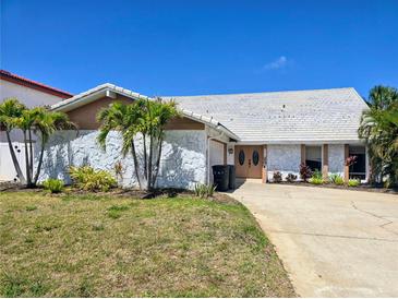 Charming single Gathering home featuring a stone facade and a well-maintained front yard with palm trees at 5012 Ensign Loop, New Port Richey, FL 34652
