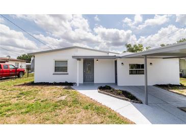 Charming white house featuring a covered entrance and well-manicured lawn at 5210 S 80Th St, Tampa, FL 33619