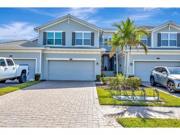Charming townhome showcases a well-maintained exterior, lush landscaping, and inviting curb appeal under a sunny sky at 915 Tidewater Shores Loop, Bradenton, FL 34208