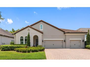 Beautiful one-story home featuring a well-manicured lawn, brick driveway and lovely landscaping at 1104 Isobel Reserve Ln, Tampa, FL 33613