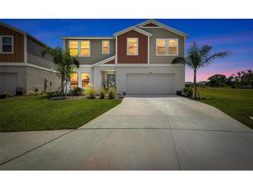 Charming two-story home with a well-manicured lawn and spacious driveway at 12710 Hysmith Loop, Parrish, FL 34219