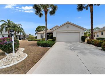 Charming home with well-manicured landscaping and a spacious two-car garage, complemented by lush palm trees at 2258 Preservation Green Ct, Sun City Center, FL 33573