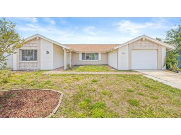 Charming single-story home featuring a brick pathway, neutral paint scheme, and a well-maintained front lawn at 3431 Springfield Dr, Holiday, FL 34691
