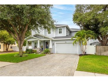 Beautiful two-story home with manicured lawn, paver driveway, and lush landscaping at 3611 W Royal Palm Cir, Tampa, FL 33629
