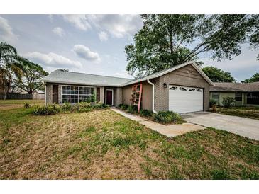 Charming single-story home with brick accents, attached garage, and a cozy landscaped front yard at 7763 Jenner Ave, New Port Richey, FL 34655