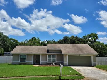 Charming single-story home featuring a well-manicured lawn and an attached two-car garage at 827 Creekside Ln, Palm Harbor, FL 34684