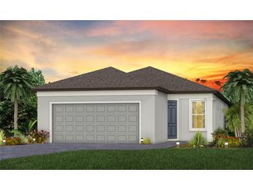 Charming single-story home with a gray exterior, two-car garage, and a well-manicured lawn under a vibrant sunset at 9474 Shorebird Ct, Parrish, FL 34219