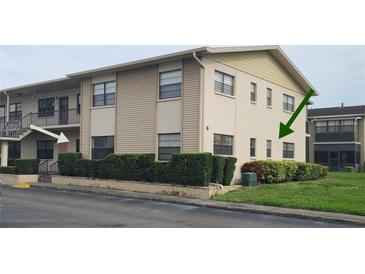 Two-story condo unit featuring neutral siding and a well-manicured hedge at 5967 Terrace Park N Dr # 101, St Petersburg, FL 33709