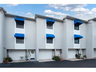 Charming townhome exterior with blue awnings, white trim and welcoming front entrances at 745 Pinellas Bayway S # 206, St Petersburg, FL 33715