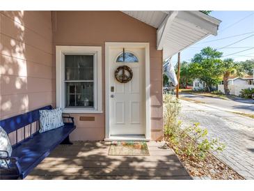 Inviting front door with wreath, blue bench, and charming curb appeal in a desirable location at 1174 8Th N St, St Petersburg, FL 33701