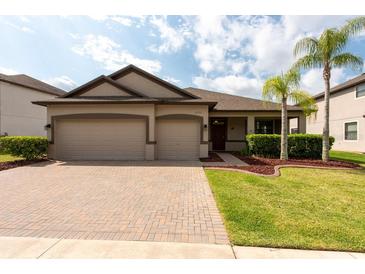 Charming one-story home featuring a paver driveway, two-car garage, and well-maintained landscaping at 12352 Crestridge Loop, New Port Richey, FL 34655