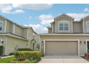 Inviting two-story home with an attached two-car garage and well-maintained front yard at 513 Harbor Springs Dr, Palm Harbor, FL 34683