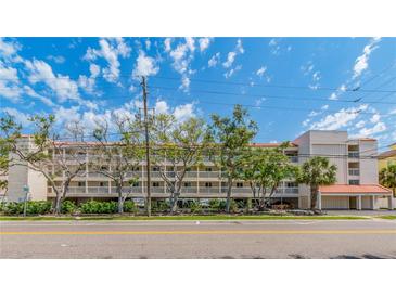 Full exterior view of the condominium complex with multiple balconies, a street view and a landscaped median at 640 Bayway Blvd # 302, Clearwater Beach, FL 33767