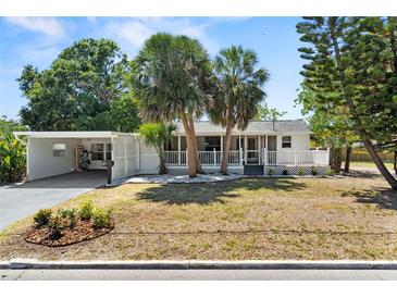 Charming single-story home with mature palm trees, a covered porch, and a well-maintained front yard at 7201 5Th N Ave, St Petersburg, FL 33710