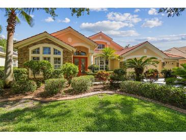 Charming home featuring mature landscaping, a clay tile roof, and a welcoming entrance at 10229 Waterside Oaks Dr, Tampa, FL 33647
