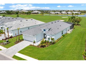 Beautiful single-story home featuring a gray tile roof and a spacious well-manicured lawn at 15817 San Lazzaro Ave, Bradenton, FL 34211