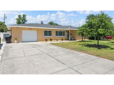 Inviting single-story home with a well-manicured lawn and a spacious driveway leading to an attached garage at 4027 25Th N Ave, St Petersburg, FL 33713