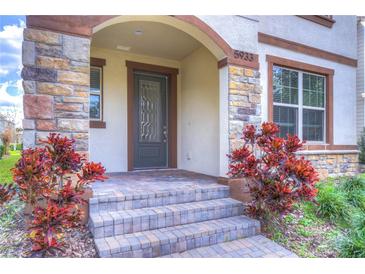 Charming home entrance featuring a stone-accented facade and a decorative front door at 5933 Caldera Ridge Dr, Lithia, FL 33547