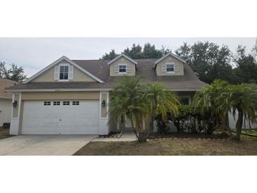 Charming two-story home with a well-maintained lawn, mature palm trees, and an attached two-car garage at 6213 Crickethollow Dr, Riverview, FL 33578