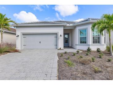 Charming single-story home boasts a gray tiled roof, two car garage, and attractive landscaping at 7610 Addison Ave, Bradenton, FL 34210