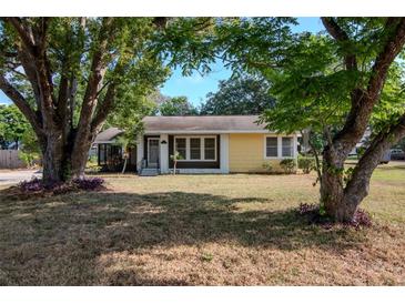 Charming single-story home featuring a welcoming front yard, mature trees, and a yellow exterior at 108 E Morgan St, Brandon, FL 33510