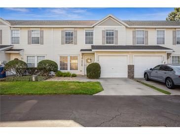 Inviting townhouse exterior with attached garage and manicured lawn at 13310 Thoroughbred Loop, Largo, FL 33773