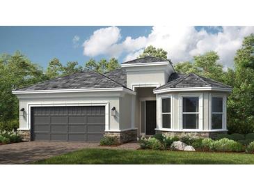 Charming single-story home features a two-car garage, a welcoming entryway and beautiful landscaping at 29807 Imperati Blvd, Wesley Chapel, FL 33543