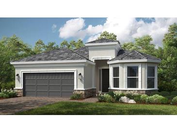 Charming single-story home with a gray roof, stone accents, lush landscaping, and a two-car garage at 29825 Imperati Blvd, Wesley Chapel, FL 33543
