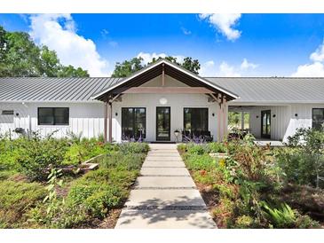 Charming exterior showcasing a landscaped front yard and modern farmhouse design at 3440 Crenshaw Lake Rd, Lutz, FL 33548