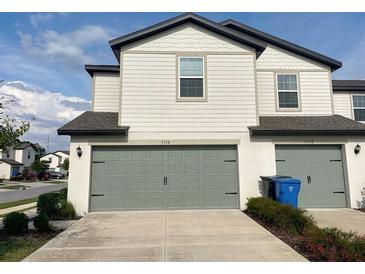 Charming townhome with a gray garage door and concrete driveway at 5310 Companion Ln, Tampa, FL 33619