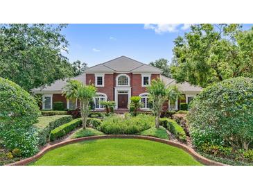 Stately brick home with manicured landscaping and symmetrical design exudes curb appeal at 6310 W Maclaurin Dr, Tampa, FL 33647