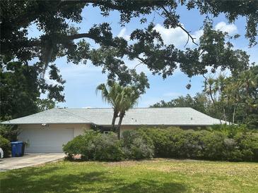 Charming single-story home with lush landscaping, mature trees, and an attached two-car garage at 1445 72Nd Ne Ave, St Petersburg, FL 33702