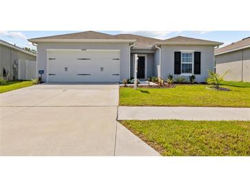Charming single-story home with a well-manicured lawn, two car garage, and a welcoming entrance at 14498 Whitewater Way, Brooksville, FL 34604