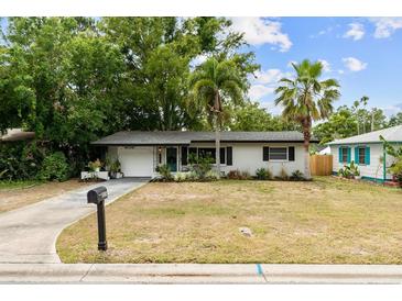 Charming single-story home with mature trees and a well-maintained lawn at 1526 San Mateo Dr, Dunedin, FL 34698