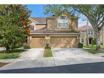 Inviting tan two-story home featuring a two-car garage and well-maintained landscaping at 18939 Duquesne Dr, Tampa, FL 33647