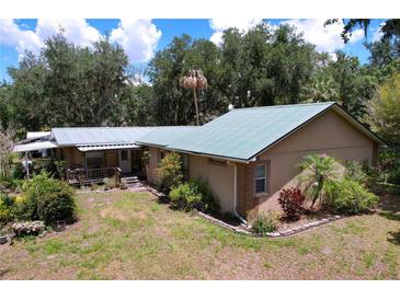 Ranch-style home featuring a metal roof, exterior brick accents, and a well-maintained yard at 3544 Porter Rd, Lithia, FL 33547
