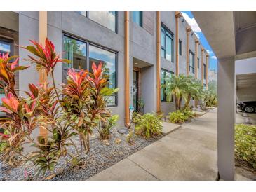 Modern townhome with lush tropical landscaping and a sleek gray exterior at 4047 Gauge Line Loop, Tampa, FL 33624