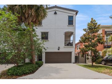 Charming stucco home featuring a two-car garage, balcony, and well-manicured landscaping at 412 S Albany Ave # 2, Tampa, FL 33606