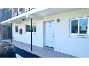 Low-rise apartment building with a white exterior and visible unit number 167, showing windows and door at 4560 Overlook Ne Dr # 167, St Petersburg, FL 33703