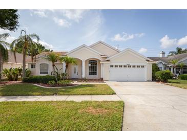 Charming single-story home with well-manicured lawn, mature landscaping, and a two-car garage at 7838 Trail Run Loop, New Port Richey, FL 34653