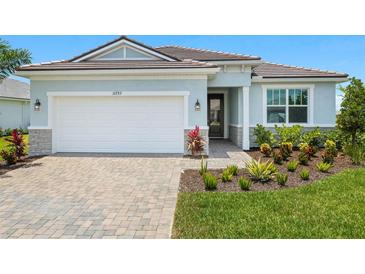 Charming single-story home featuring a paver driveway, well-manicured lawn, and a two-car garage at 11737 Myakka Blue Dr, Venice, FL 34293