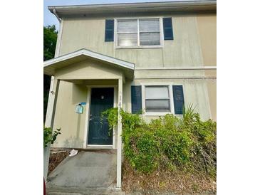 Two-story townhome featuring a covered entry and traditional windows with decorative shutters at 144 Douglas W Rd # F, Oldsmar, FL 34677