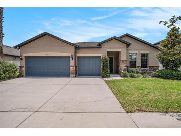 Charming single-story home featuring a three-car garage and beautifully landscaped front yard at 1512 Banner Elk St, Valrico, FL 33594