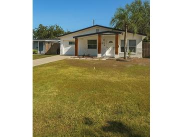 Charming single-story home featuring a well-manicured lawn and inviting front porch at 1778 New Hampshire Ne Ave, St Petersburg, FL 33703