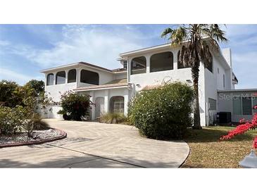 Beautiful two-story white house with a circular driveway and mature landscaping at 2333 Camp Indianhead Rd, Land O Lakes, FL 34639