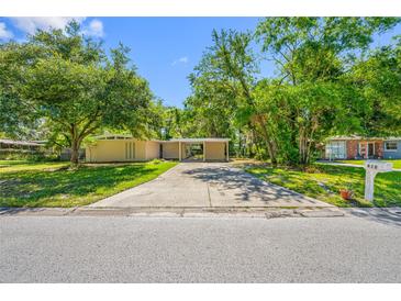 Charming single-story home with a covered carport and mature trees shading the front yard at 810 W River Dr, Temple Terrace, FL 33617